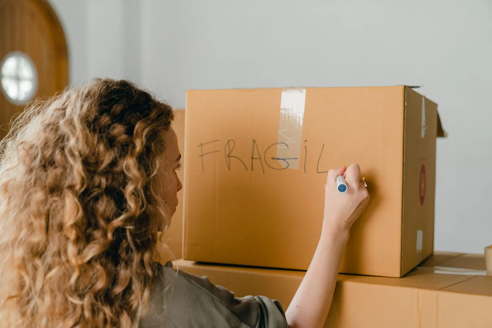 A teacher labeling a packing box before a move