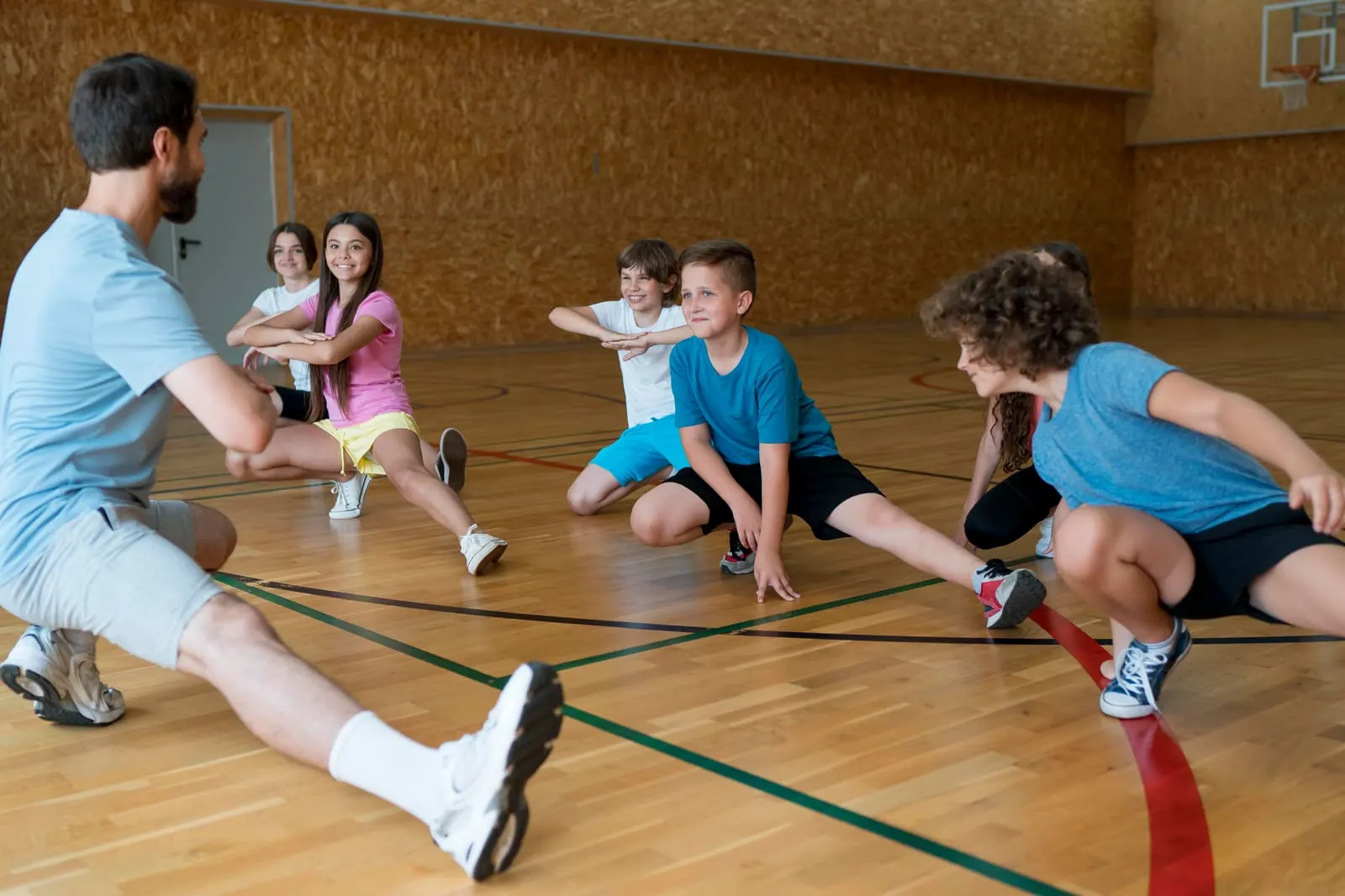 Children stretching during a physical education class in a gym