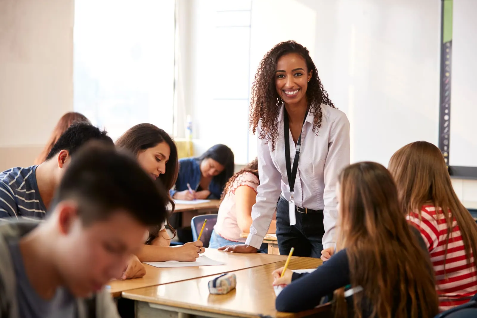 A secondary teacher working with teenage students at their desks