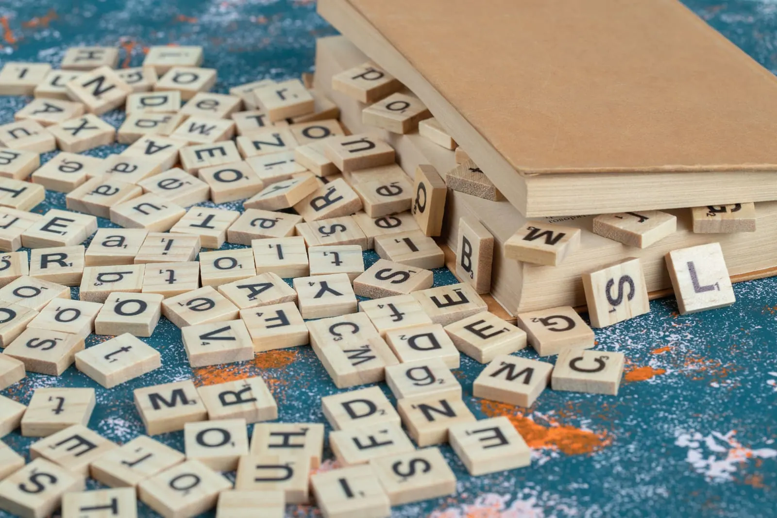 Wooden letter tiles from a word game scattered on a table